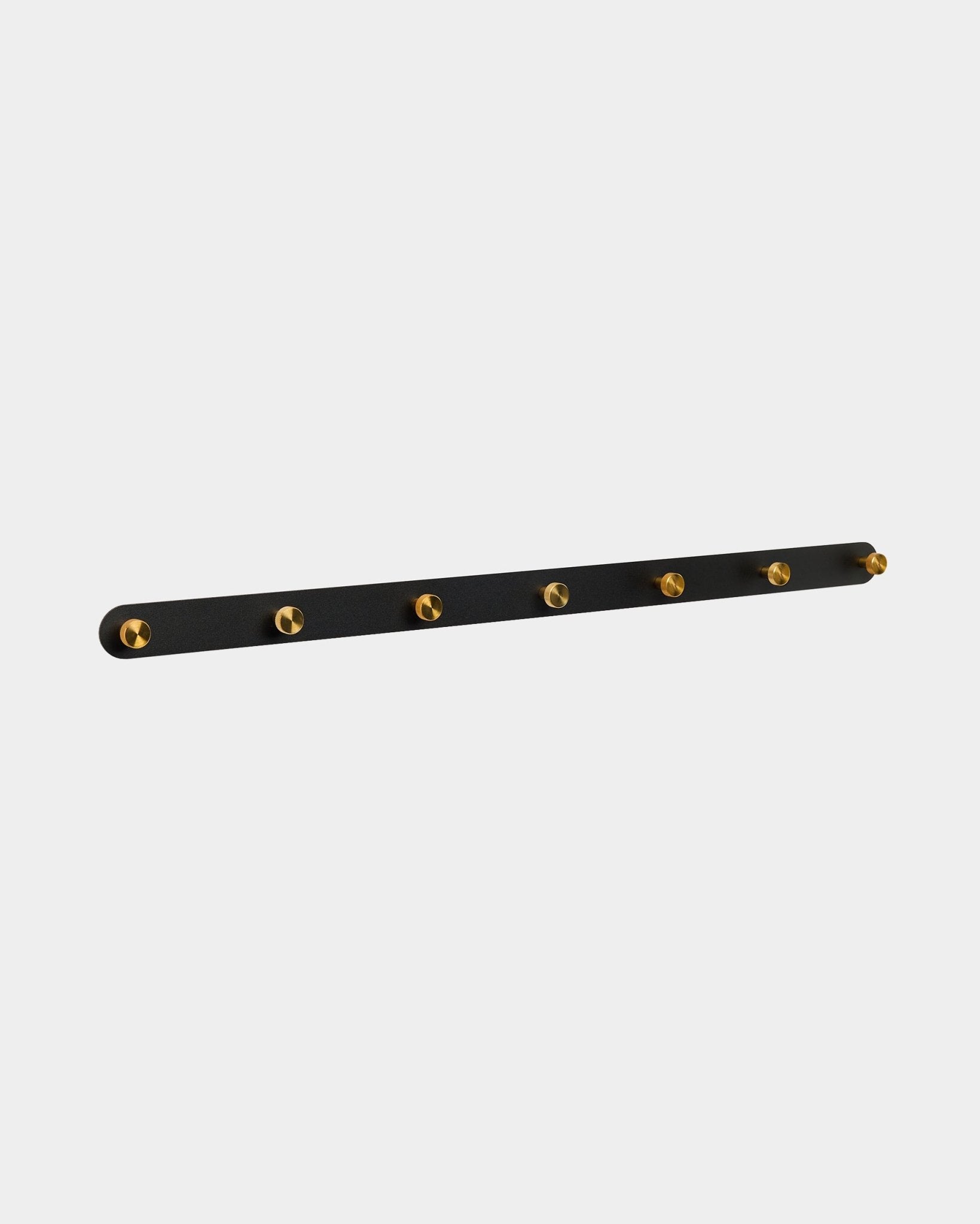 Norr Coat Hook Rack by WoodUpp with 7 brass hooks on a black acoustic panel, designed as a hallway organizer compatible with Akupanel collections.